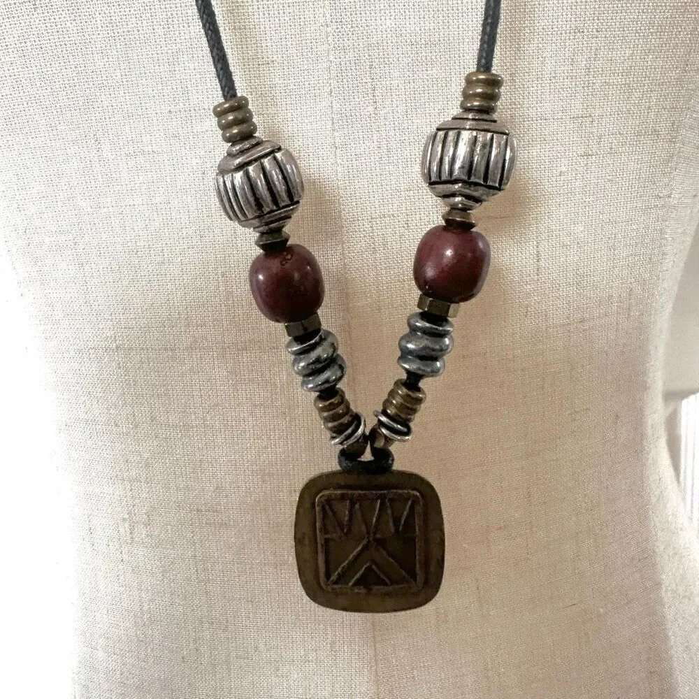 Baer SF sterling silver and brass pendant necklace on black cord
